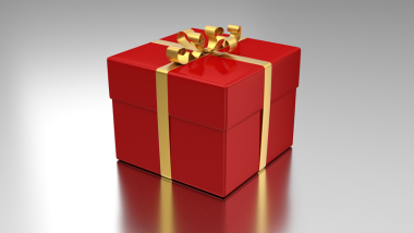 Red gift box with gold bow on silver background.